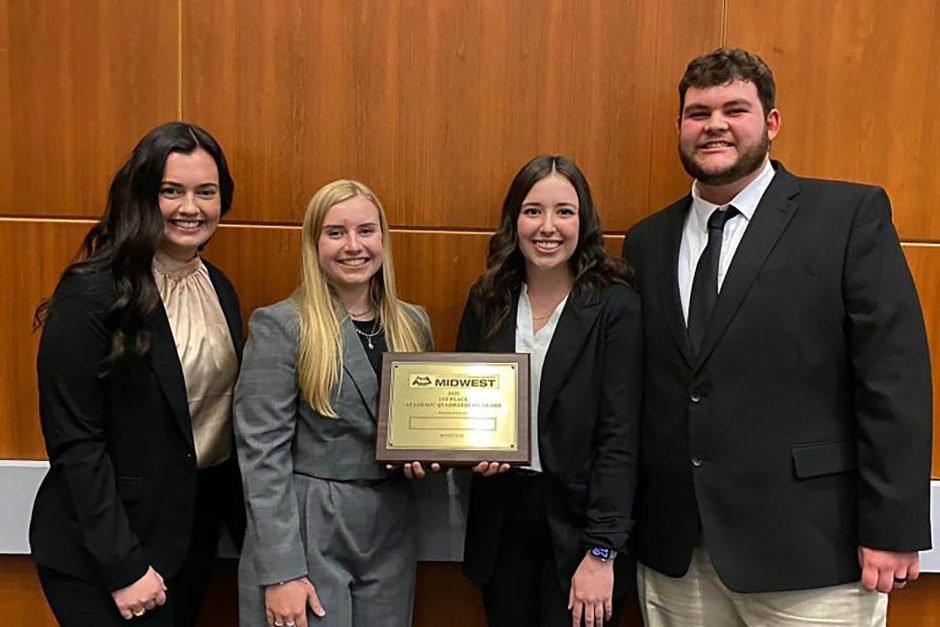 Four students with plaque