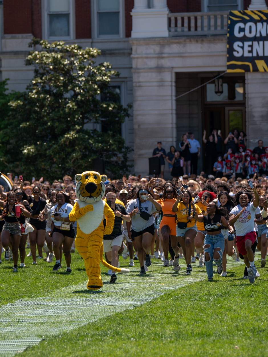 Truman the Tiger mascot runs with students