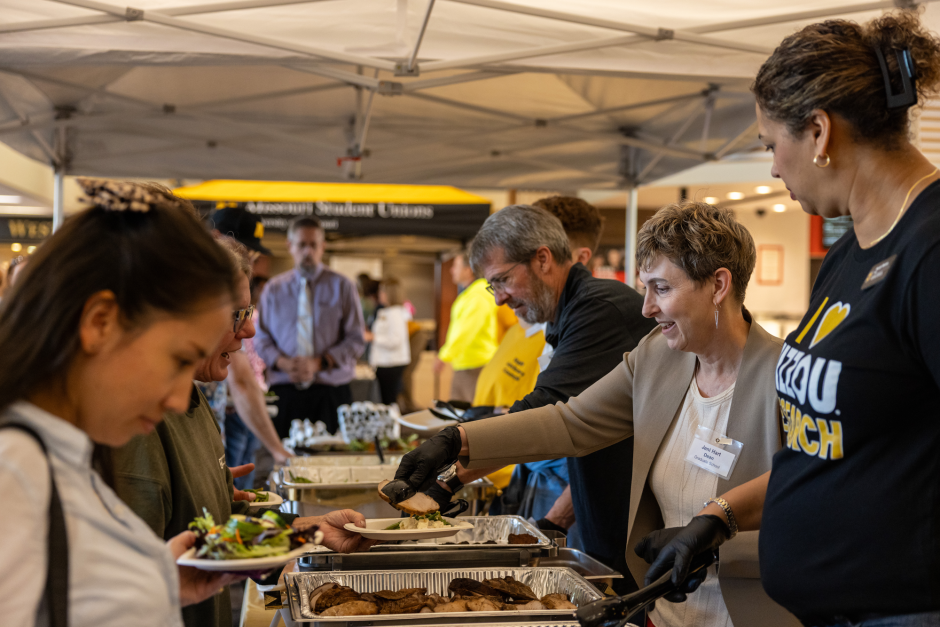Staff members serve lunch to fellow employees