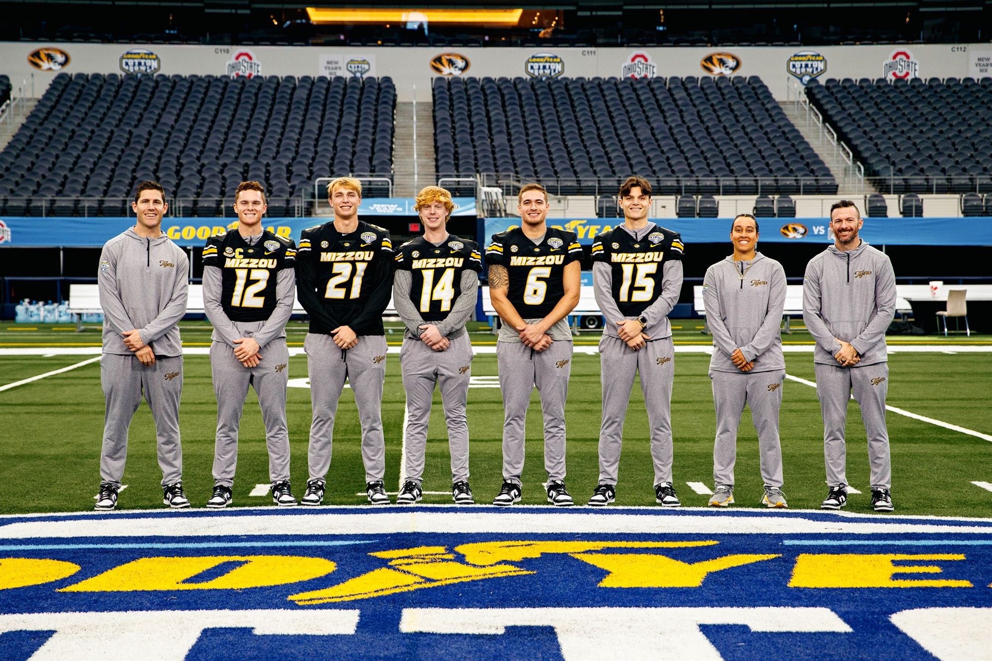 group of football players and coaches standing on the field at the Cotton Bowl