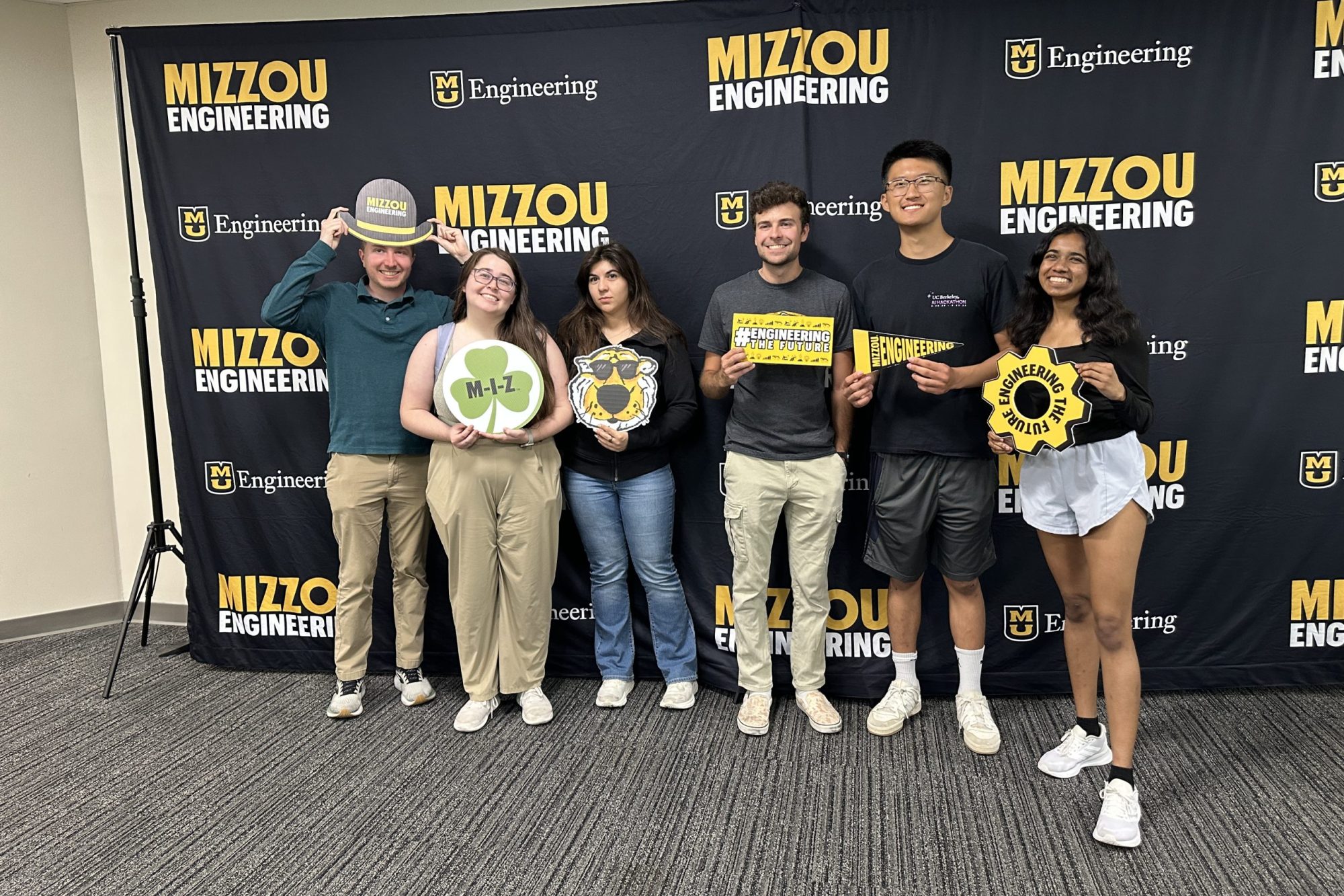 group of people posing for a photo in front of a Mizzou Engineering background